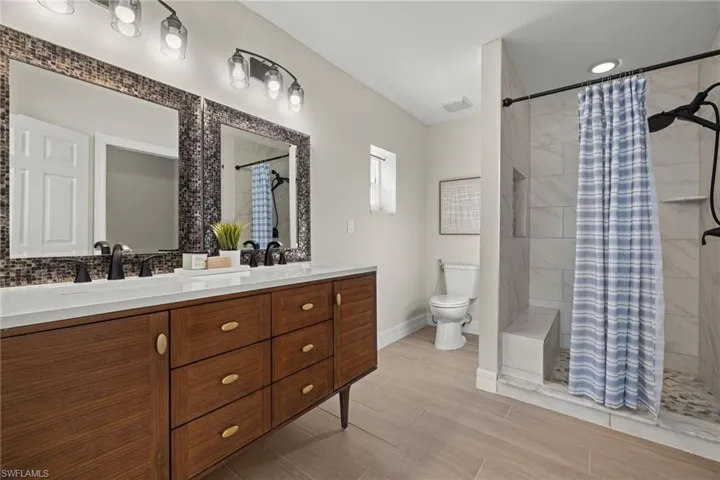 Bathroom with a shower with curtain, toilet, and vanity