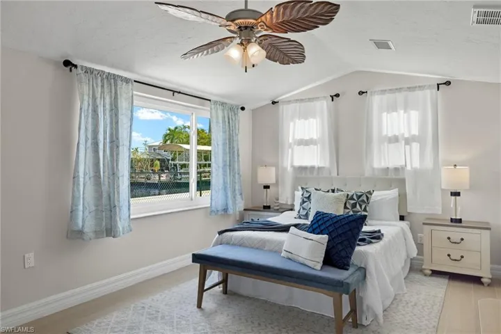 Bedroom featuring light hardwood / wood-style flooring, vaulted ceiling, and ceiling fan