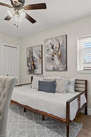Bedroom featuring ceiling fan, a closet, and hardwood / wood-style flooring