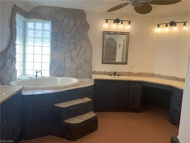 Full bath featuring a bath, ceiling fan, vanity, and tile patterned floors