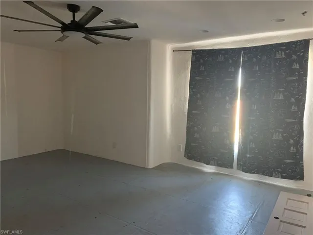 Empty room with a ceiling fan and visible vents