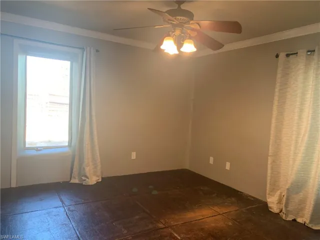 Spare room featuring ceiling fan and crown molding
