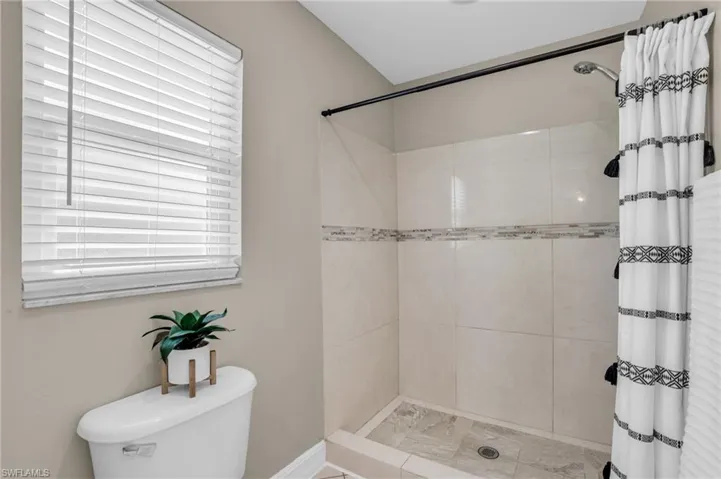Bathroom featuring a shower with curtain and toilet
