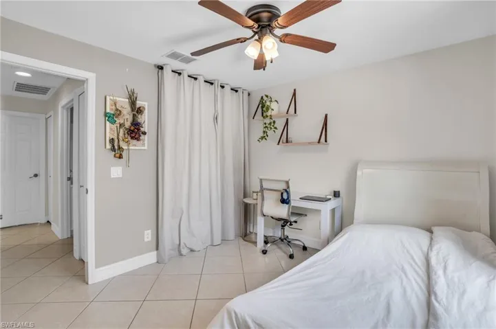Bedroom with ceiling fan and light tile flooring