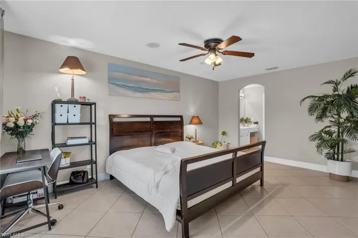 Bedroom with ceiling fan and light tile floors