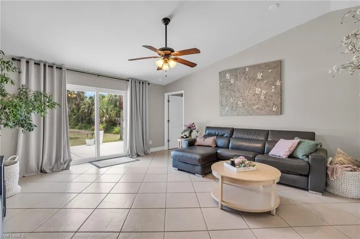 Tiled living room with vaulted ceiling and ceiling fan