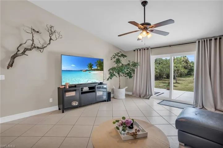 Tiled living room with high vaulted ceiling and ceiling fan