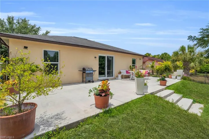 Back of house with a patio area and a lawn