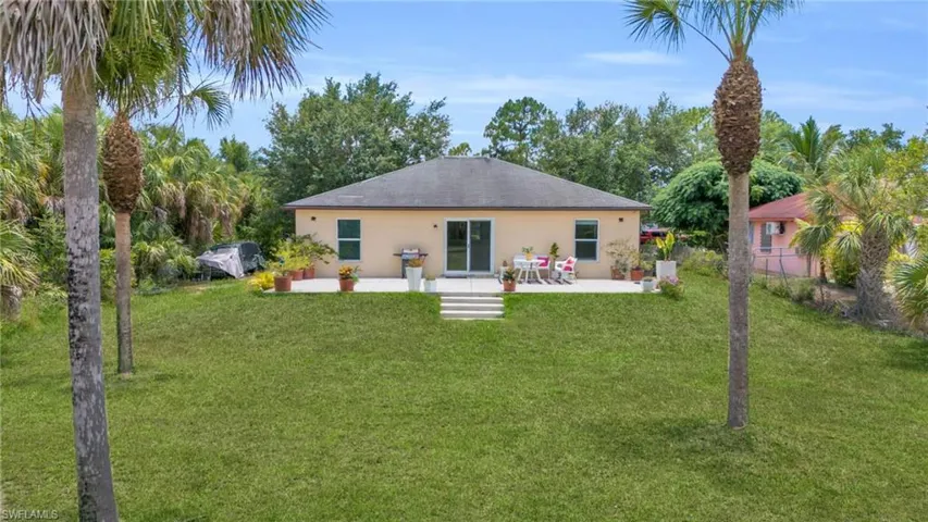 Rear view of property with a yard and a patio area