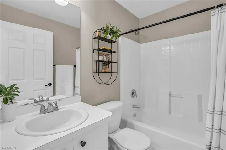 Full bathroom featuring shower / bath combo with shower curtain, oversized vanity, and toilet