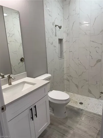 Full bathroom featuring vanity and a marble finish shower