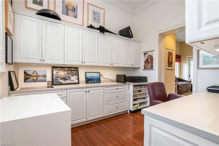 Hobby room with abundant cabinet storage space. Wood flooring.
