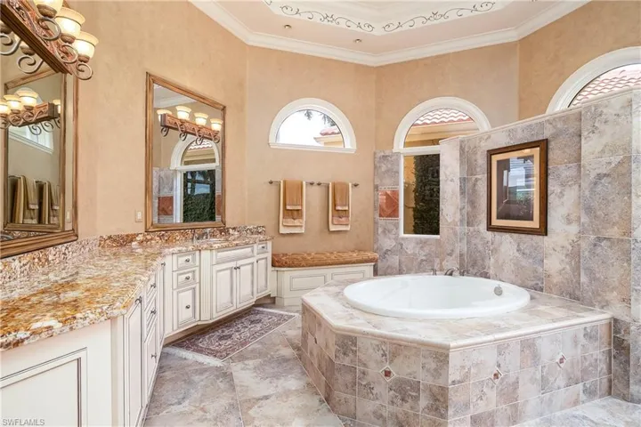 Master bath, dual sinks, soaking tub and walk-in shower. Granite countertops, custom mirrors, arched windows. Marble flooring.