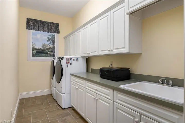 Utility room, laundry sink, abundant storage...note hand painted scene of view behind the wall. It's not a window!