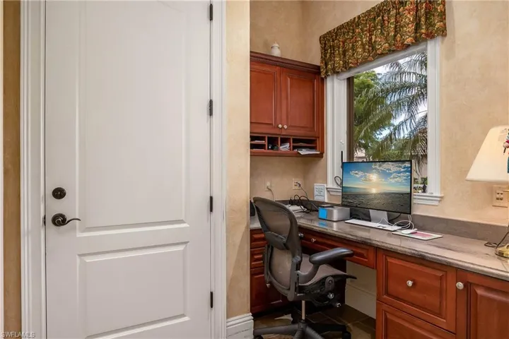 Second office/desk area at end of hallway, away from living area, door leading to garage
