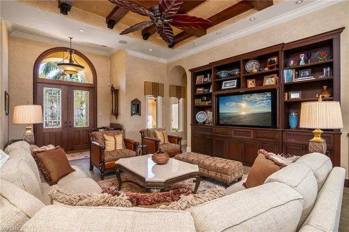Great room with wood beam ceiling and built in custom wall unit