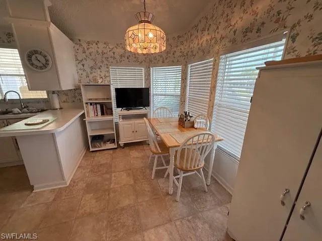 Dining room featuring a textured ceiling and wallpapered walls