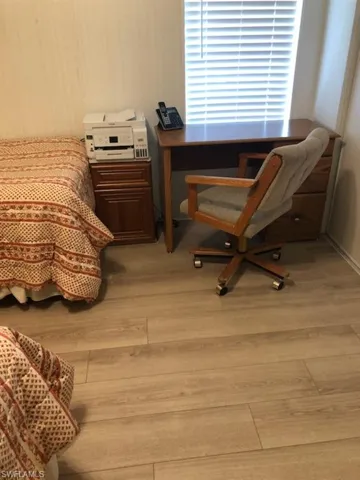 Bedroom featuring light wood-style floors and an office area