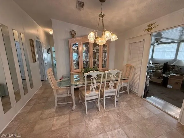 Dining room with visible vents, an inviting chandelier, and crown molding