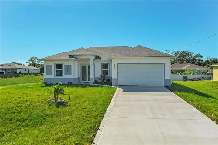 View of front of property with stucco siding, a front yard, driveway, and a garage