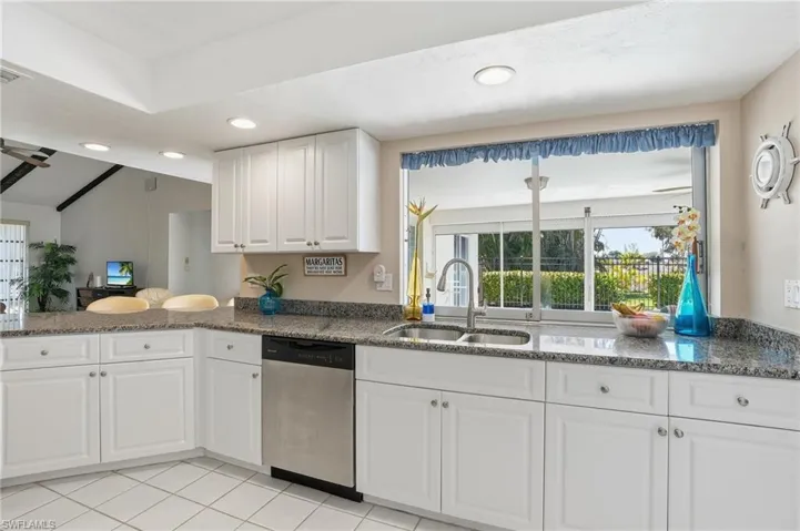 Kitchen with classic white cabinetry, granite countertops and stainless steel appliances.