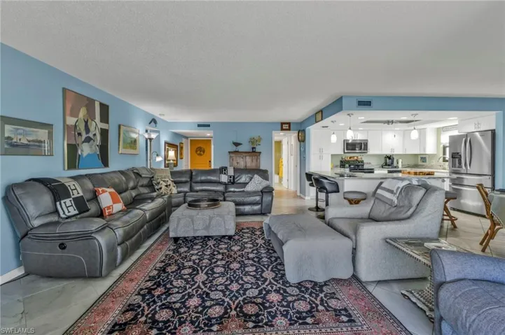 Living area featuring a textured ceiling, light tile patterned floors, and visible vents