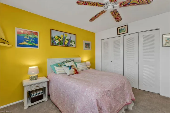 Carpeted bedroom featuring a ceiling fan, baseboards, and a closet