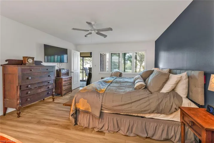 Bedroom featuring light wood finished floors, ceiling fan, and multiple windows