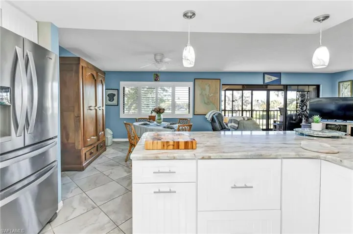 Kitchen with open floor plan, a healthy amount of sunlight, and stainless steel refrigerator with ice dispenser