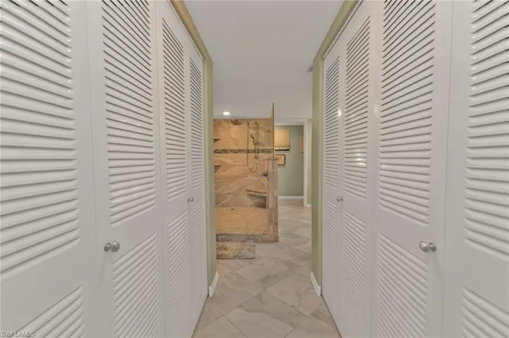 Hallway with marble finish floor and baseboards