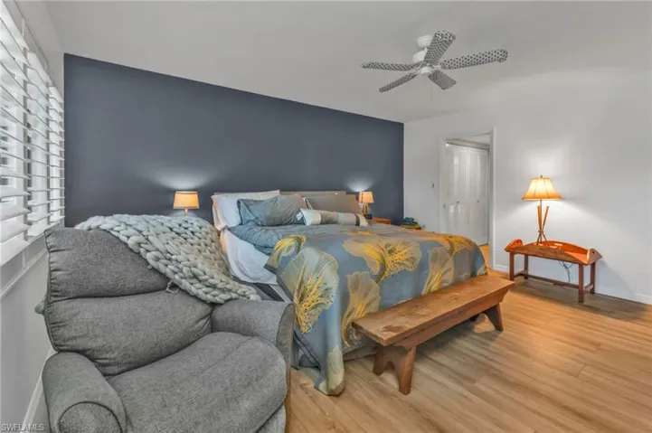 Bedroom with ceiling fan, light wood finished floors, a closet, and baseboards