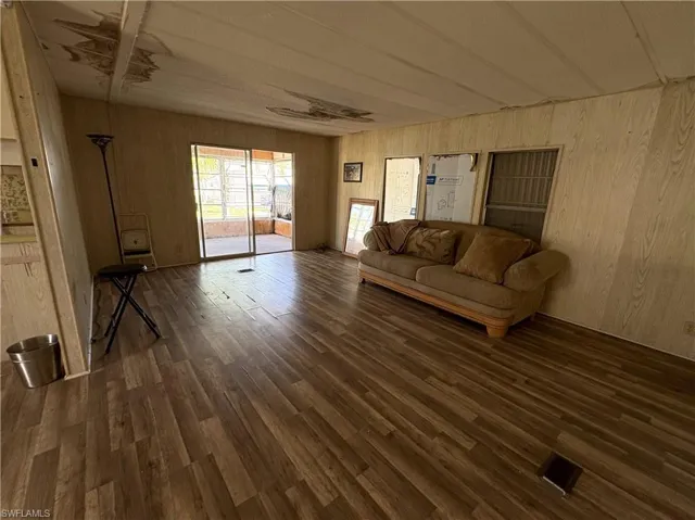 Living area featuring wood walls and dark wood-style flooring