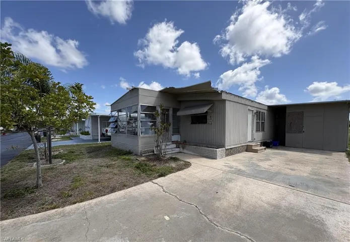 Manufactured / mobile home with entry steps, a sunroom, and concrete driveway