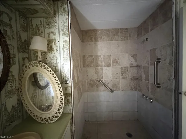 Bathroom featuring tiled shower and vanity