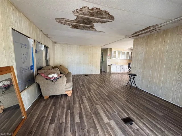 Sitting room featuring wood walls and dark wood-style flooring