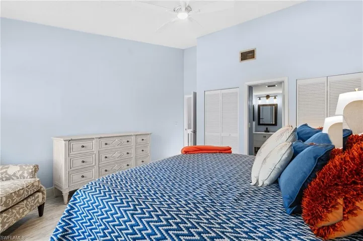 Primary Bedroom 2 featuring visible vents, two closets, a ceiling fan, a high ceiling, and light wood finished floors