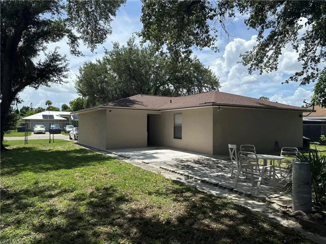 Rear view of house with a lawn and a patio area