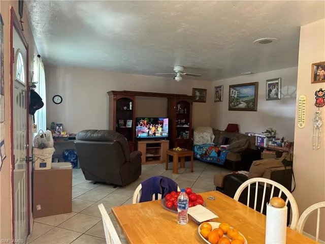 Tiled dining area featuring a textured ceiling and ceiling fan