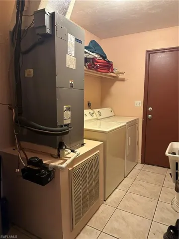 Washroom featuring separate washer and dryer and light tile floors