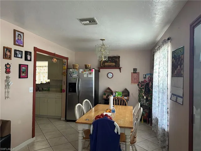 Dining room with a notable chandelier and light tile floors
