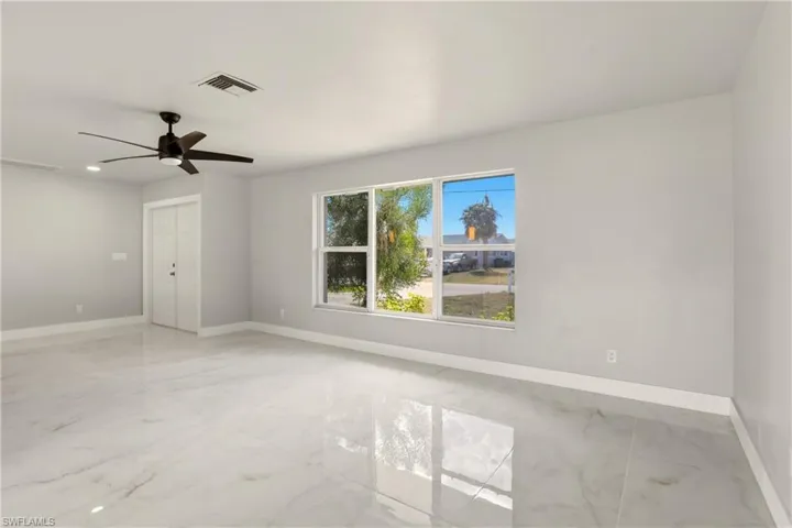 Empty room with light marble finish floors, a ceiling fan, and recessed lighting