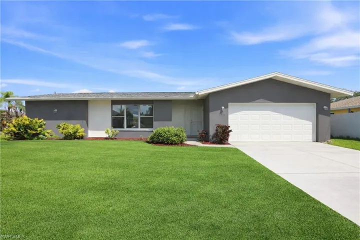 Ranch-style house featuring stucco siding, a front lawn, and a garage