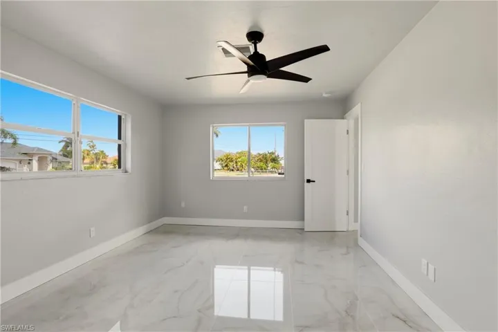 Unfurnished room with light marble finish flooring and a ceiling fan