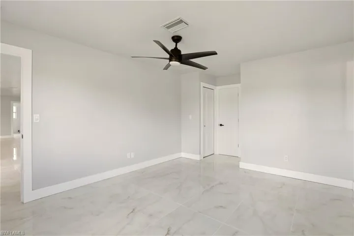 Unfurnished room with a ceiling fan and baseboards