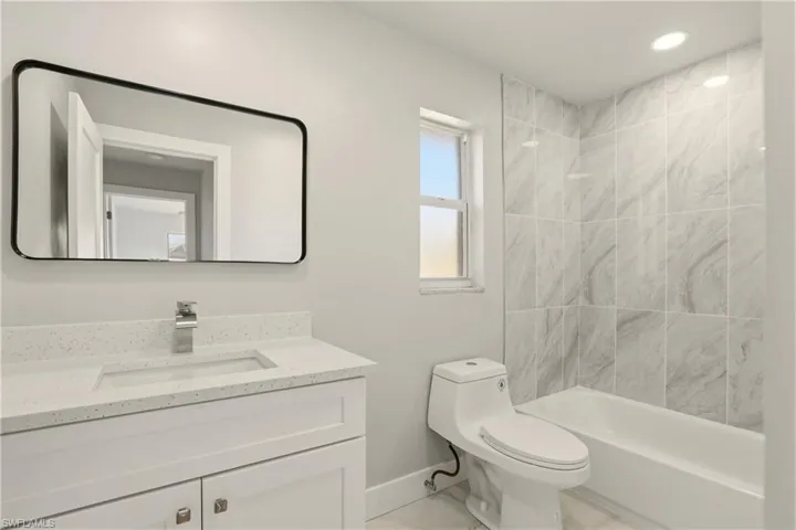 Bathroom featuring vanity, tub / shower combination, and recessed lighting