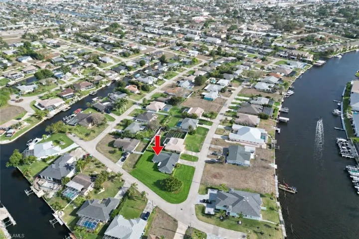 Aerial view of property's location featuring a nearby body of water and nearby suburban area