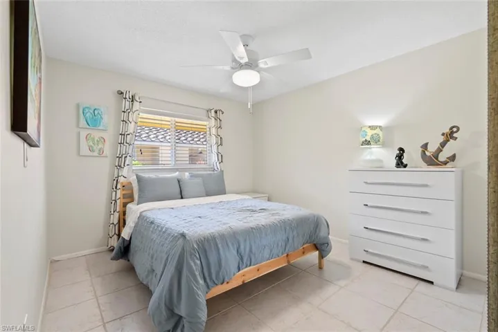 Bedroom featuring light neutral wall tones and square tile flooring