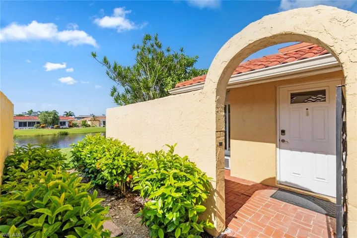 Archway entry leading to a solid white front door with transom window