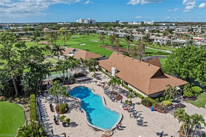 Extensive outdoor amenity area featuring a freeform swimming pool, paver deck, and surrounding lounge seating