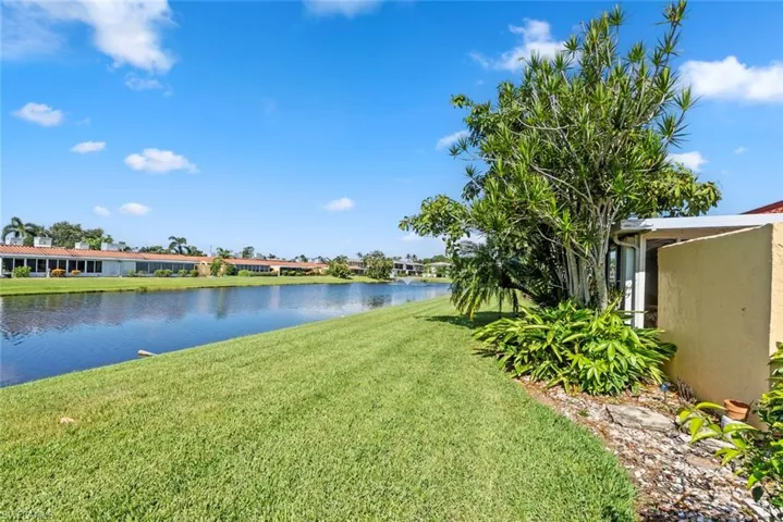 Expansive waterfront property featuring a manicured lawn leading to a serene canal